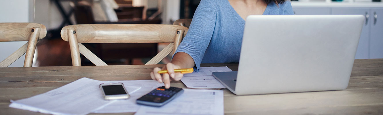 A woman's hand pressing buttons on a calculator.